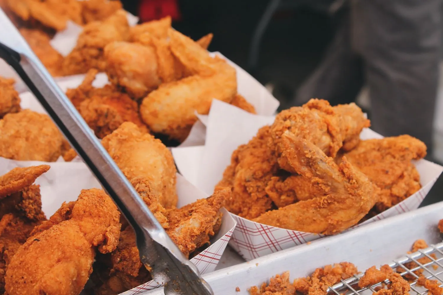 Multiple baskets of crispy fried chicken wings at MBL & Q Burger, a Fried Chicken Shop in Irvine